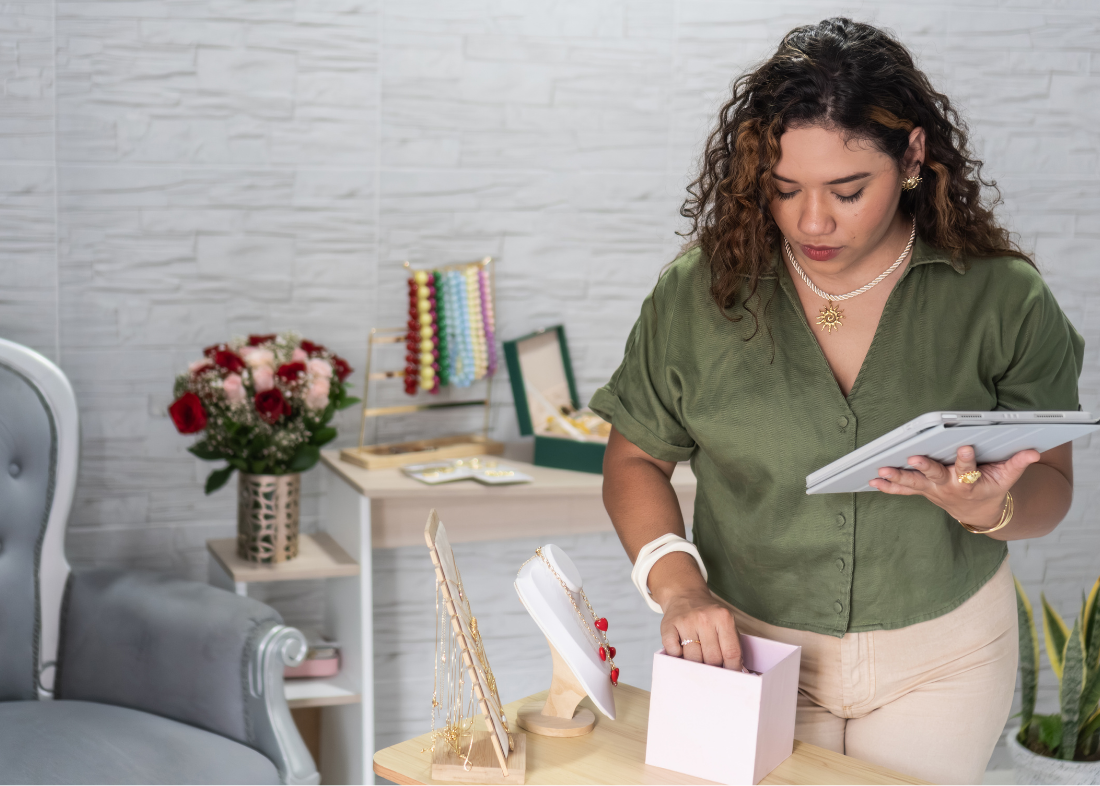 Retail associate browsing products on tablet in clothing store
